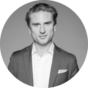 Professional portrait of a man in a suit, exuding confidence with a subtle smile. This image conveys authority and professionalism, suitable for a business profile.