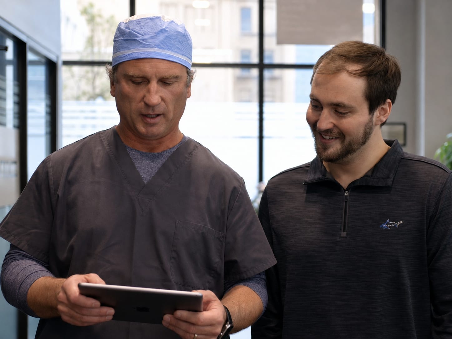 Surgeon and patient reviewing hair restoration options on a tablet at the Omaha clinic