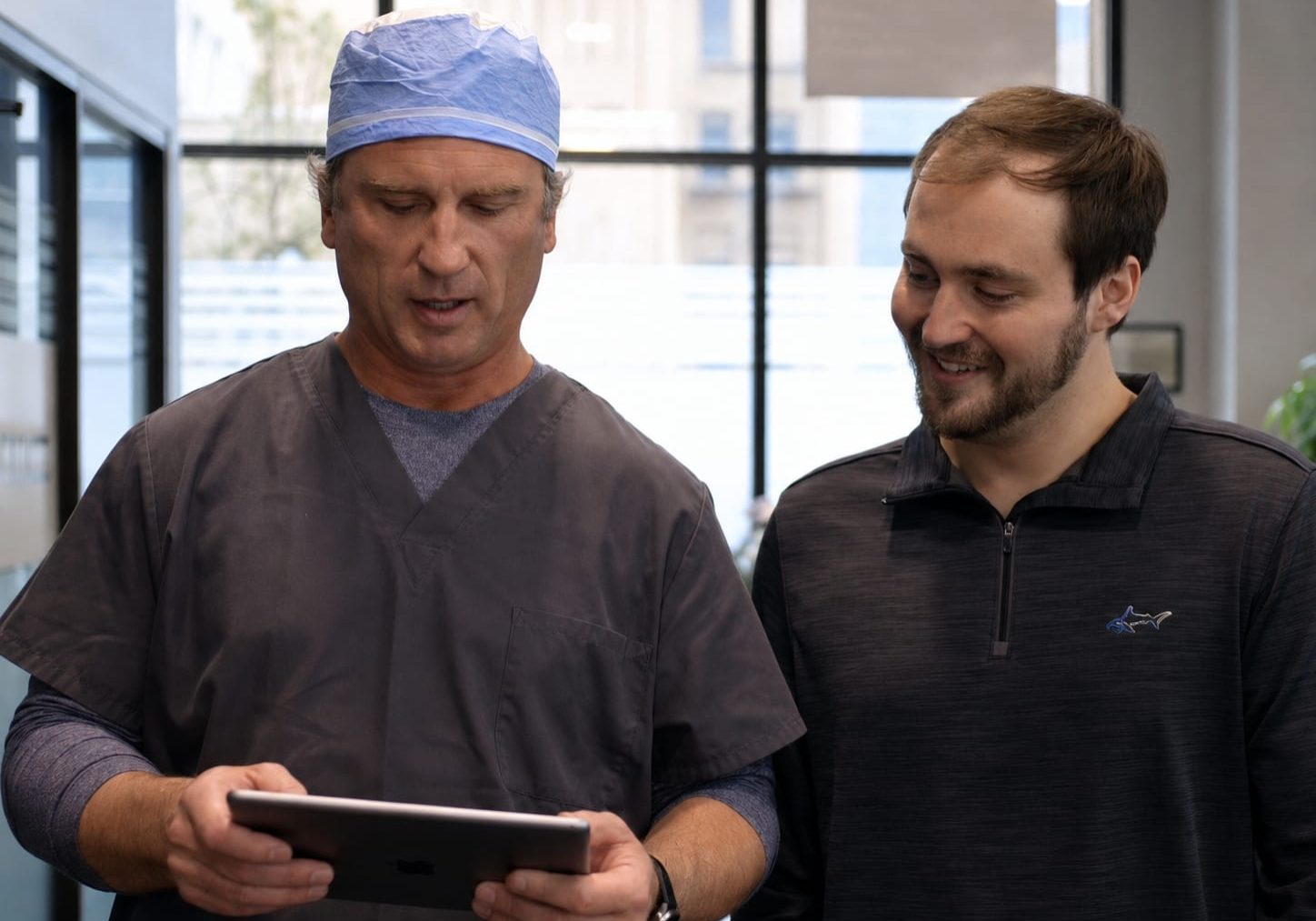Surgeon and patient reviewing hair restoration options on a tablet at the Omaha clinic